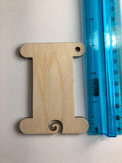 The larger wood bobbin next to a ruler to show size. Wooden Bobbins / Spools - 3 Packs Art & Crafting Materials Raven King Crafts