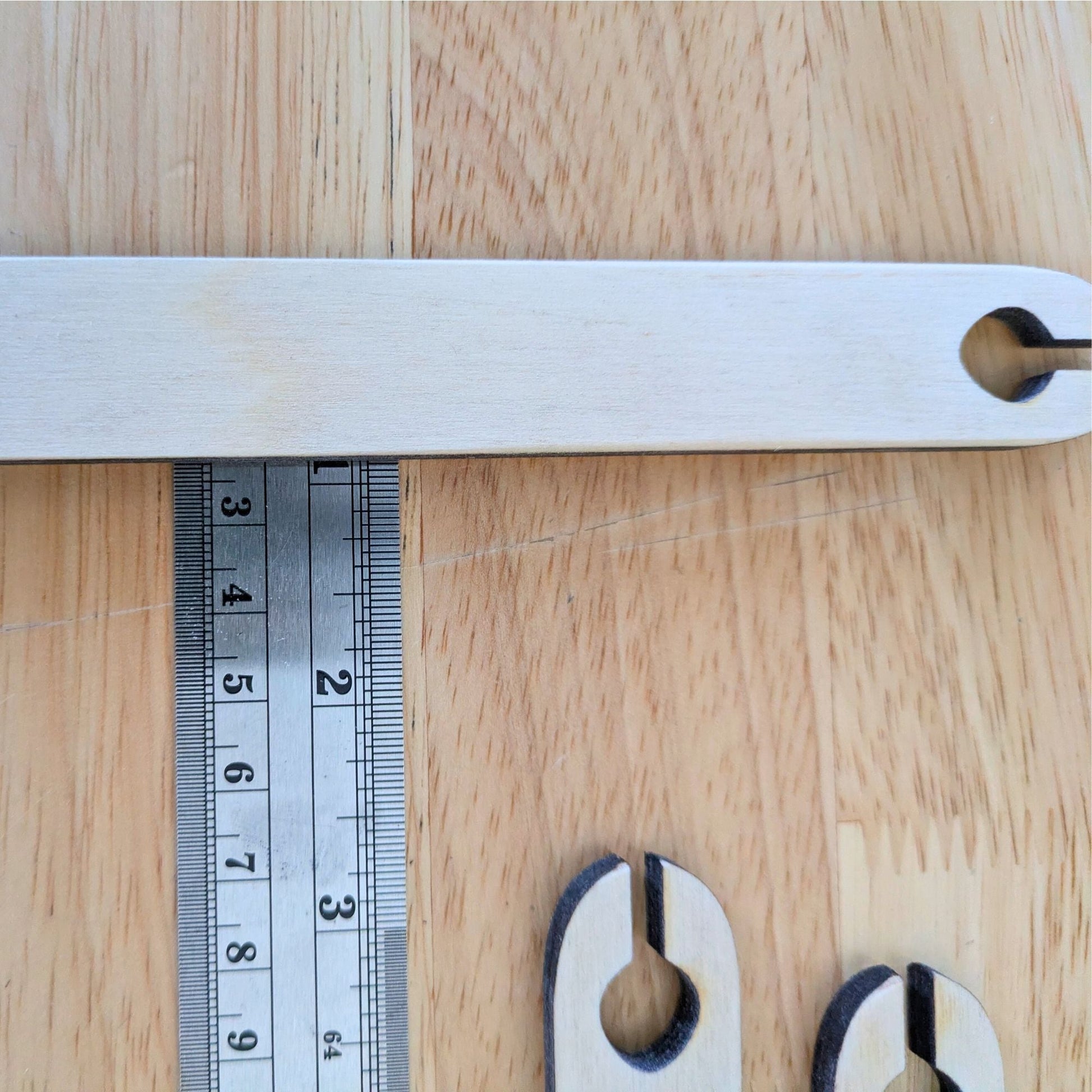 One of the larger shuttle sticks on a ruler to show the width of the shuttle. Wooden Shuttle Stick Set - 4 Weaving Shuttles Art & Crafting Materials Raven King Crafts
