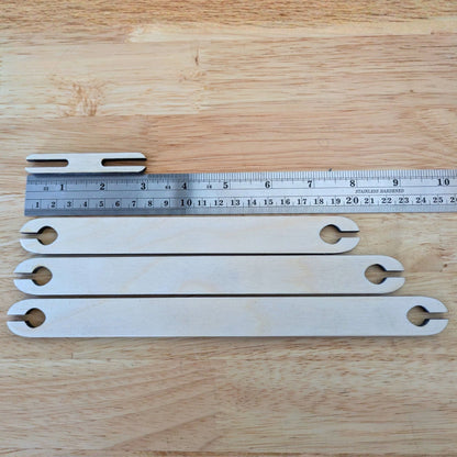The shuttles next to a ruler to show the length of the shuttles. Wooden Shuttle Stick Set - 4 Weaving Shuttles Art & Crafting Materials Raven King Crafts
