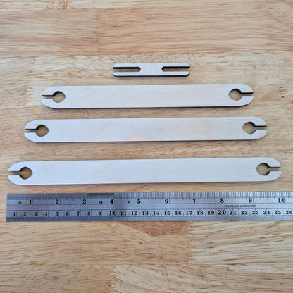 The 4 shuttle sticks next to a metal ruler for scale. Wooden Shuttle Stick Set - 4 Weaving Shuttles Art & Crafting Materials Raven King Crafts