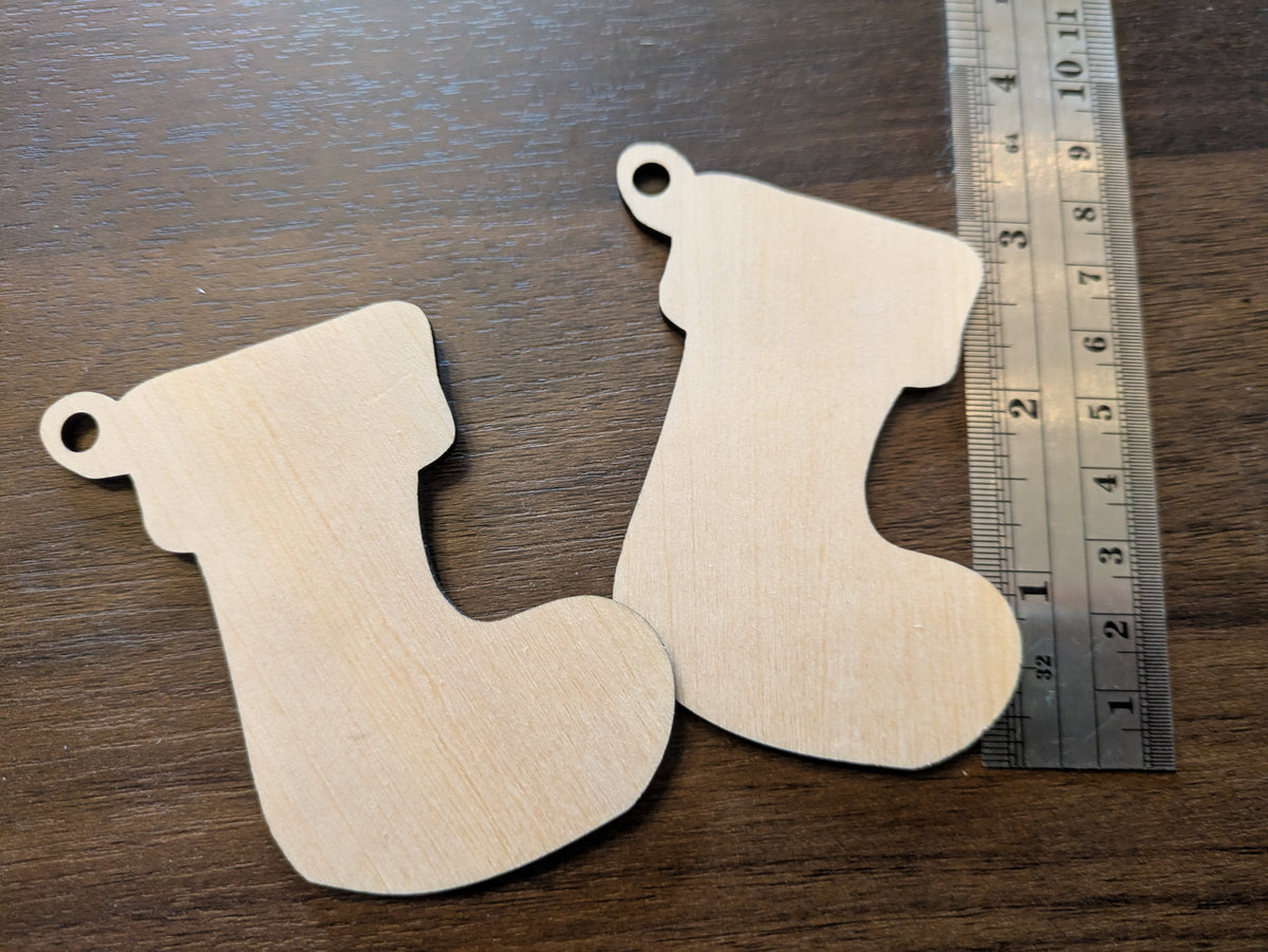 The wooden Christmas stocking ornament blanks next to a ruler.